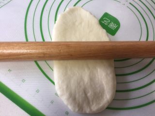 8、烫种牛奶吐司,取出一个松弛好的面团擀开，擀成牛舌状。