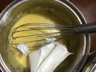 11、蒸蛋糕,取一勺蛋白糊到蛋黄糊里先翻拌均匀