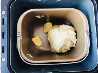 8、奶酪吐司（面包机版）,面团揉至表面光滑状就可以加入黄油。开启第2个和面程序。差不多20分钟。取适量面团检查其状况，如果可以拉出透明薄膜，也表示已经揉至完全阶段。