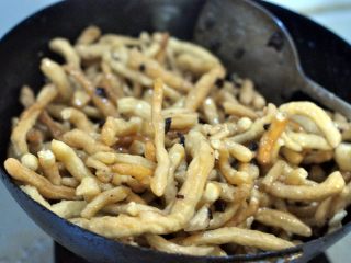 13、蔓越莓萨琪玛,此时将沙琪玛条和蔓越莓一起倒入锅中，不停的翻炒，尽量让每一根沙琪玛条粘上糖浆。