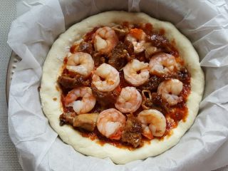 16、鸡肉海鲜披萨,16．酱料的上面将黑虎虾仁和鸡腿肉摆满。