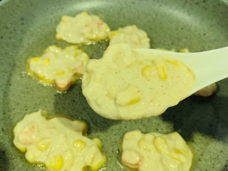 16、鲜虾玉米饼,锅加食用油，大火热锅，转小火，舀入鲜虾玉米糊