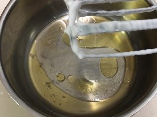 5、葡萄干蛋糕,玉米油和清水混合，加入盐，用打蛋器低速搅拌至混合。