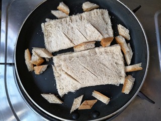 9、全麦土司香蕉派——无油低卡健身餐,平底锅预热(不用放油,不用放油,不用放油,重要的话说三遍),将香蕉派下锅,切下来的土司边也不要浪费,可以切成小块一起下锅。