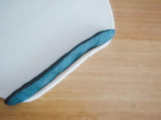 15、创意奶牛花纹切片馒头,然后我们把黑色长条加入其中,加一个卷一下白色面皮在加下一条黑色面条