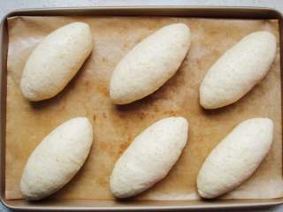 13、全麦软欧包,粘合好封口向下放，整理成橄榄形状。依次做好，放入烤盘中。盖上保鲜膜开始第二次发酵。（时长约40分钟）