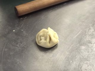 10、白皮酥,完成馅料后继续处理面皮：将刚才的卷卷收口朝上，用筷子在中间压一下，把两头往中间并拢。