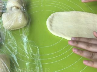 11、淡奶油吐司,取松弛好面团 拍扁  擀成椭圆形