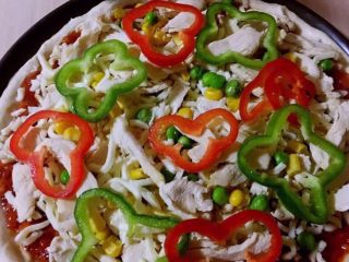 14、至尊披萨,摆放上青红椒、虾仁，口蘑片，磨入黑胡椒粒撒上少许盐