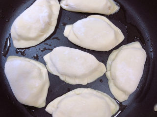 14、鸡蛋韭菜盒子,平底锅中加入少许油，放入韭菜盒子，盖盖儿中小火煎制。