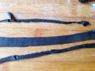 15、小黄人莲蓉包,黑色面团取一小块搓成长条后压扁擀成长方形薄片（越薄越好）裁成约0.8cm的条