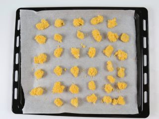 12、香烤鱼米花,把沾满面包糠的鲽鱼一快块放在烘焙纸上，每个之间留一些空隙。