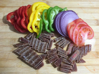 2、美味的牛排披萨,这个时间准备馅料：将洋葱，红椒，黄椒，青椒切成丝，西红柿切成片，牛排切成小条。