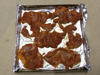 2、#吐司新吃法之一#新奥尔良三明治,在烤盘中铺锡纸，将腌制好的鸡腿肉铺在上面