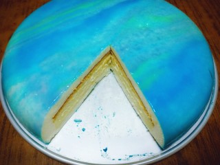 17、璀璨星空慕斯蛋糕,最后用粉刷沾一点糖粉，在蛋糕上方轻轻弹两下，作为星星点缀即可。放在冰箱冷藏两三个小时就可以吃了。