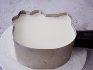 25、6寸KT猫奥利奥慕斯蛋糕,等时间到从冰箱取出慕斯蛋糕,再用吹风机对着模具四周吹一吹,用手轻轻往上提即可脱模成功