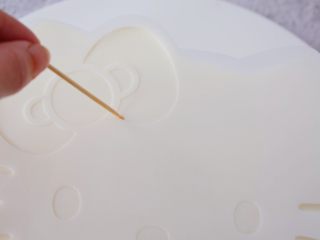 26、6寸KT猫奥利奥慕斯蛋糕,再把白色的面片放在慕斯上,用牙签画出蝴蝶结、眼睛、鼻子、胡子的位置,再把巧克力按画好的位置摆放好即可