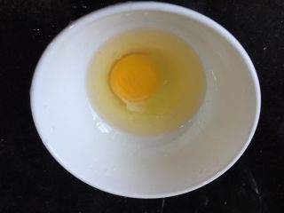 2、荷包蛋三明治,将鸡蛋磕入碗中