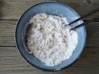 5、腐乳葱香饼,用筷子将面粉搅拌成雪花状。
