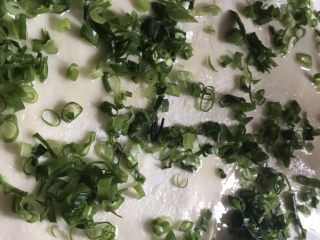 5、香脆葱花饼,先撒上盐然后铺上葱花。