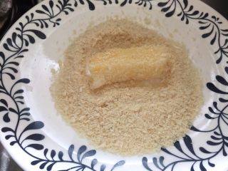 7、脆炸鲜牛奶,再放入面包糠中裹一层，将多余抖掉