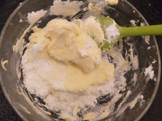 19、最经典浓郁巧克力奶酪蛋糕,把糖粉倒入奶油奶酪中用刮刀压一压。使他们大致的融合。