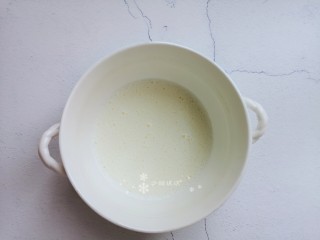 3、卡通肉松蛋糕,用蛋抽将牛奶和玉米油搅打至乳化无油珠状态。