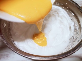 8、卡通肉松蛋糕,蛋黄液分三次倒入蛋清盆中。用翻拌的手法拌匀。