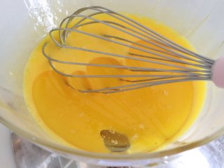 3、鲜橙方块大蛋糕,蛋黄加入10克细砂糖，搅匀糖融化，加入油，充分的搅打均匀。