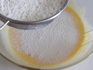 6、鲜橙方块大蛋糕,筛入低筋面粉，划井的方式拌匀，橙汁蛋黄糊就制作完成了