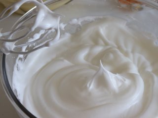 8、鲜橙方块大蛋糕,并分三次加入细砂糖打发蛋白，直到蛋白干性发泡，状态是细腻有光泽的，而且拉起打蛋器会呈现小的尖角。