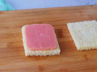 3、火腿西多士,取一片火腿放在其中一片吐司上