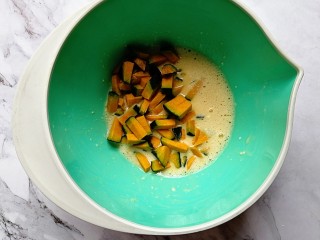 5、贝贝南瓜蒸蛋糕,倒入南瓜丁，拌匀