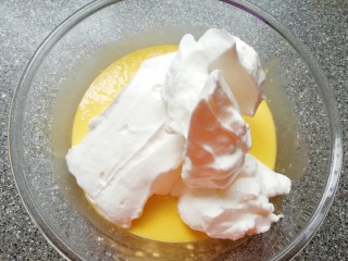 12、斑马纹戚风蛋糕(8寸),打发好的蛋白取三分之一加入到蛋黄糊里面,用硅胶刮刀采用切拌和翻拌的方法混合均匀。