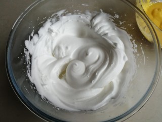 7、电饭锅戚风蛋糕,用电动打蛋器把蛋清打至粗泡（蛋清一定要装在无水无油的盆里），加入1/2糖，打发至有纹路的状态，再倒入剩余的糖，继续打发至提起打蛋头，呈直立小尖角的干性发泡的状态