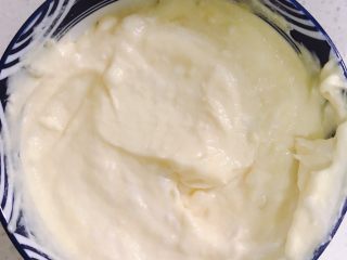 9、酸奶芝士蛋糕,把刚才拌好的芝士液倒一半到芒果里拌匀