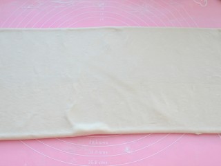 7、可颂面包,将其顺长度方向擀开，注意用力要均匀，可以撒高粉防粘，两端不规则的面片可以切掉，以免影响层次