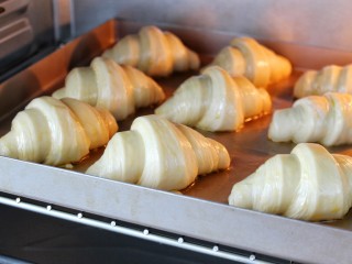 17、可颂面包,发酵至原来的两倍大，在表面刷蛋液，烤箱提前210度预热，将烤盘放进三层烤箱的中层烤至膨胀，转180度烤至表面金黄，全程烤约18-20分钟