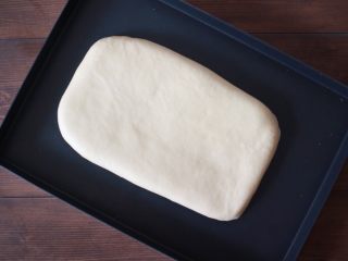 2、丹麦手撕吐司,将配方中除黄油和裹入黄油的材料一起揉成面团，能拉出厚膜，再加入黄油继续揉至扩展阶段，然后放在烤盘中擀成长方形，盖好保鲜膜放入冰箱中冷冻一小时左右