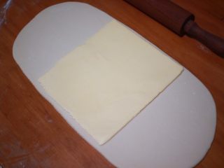 3、丹麦手撕吐司,然后取出黄油和面团，将面团擀至黄油两倍大，将黄油放在面团上，用面团包好，接缝处捏紧