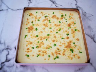12、香葱肉松蛋糕卷,烤盘铺上耐高温油布，再把蛋糕糊倒入烤盘中，表面用刮刀抹平，提出烤盘震一震，震出大气泡，再撒上葱花和肉松