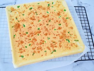 14、香葱肉松蛋糕卷,烤好马上取出震两下，把里面的热气震出来，再把蛋糕片倒扣在烤网上，拿掉烤盘，慢慢撕开油布，再翻正面过来晾至手温