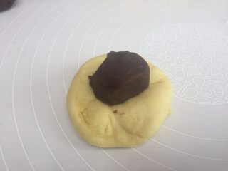 7、花朵豆沙面包,取一个面团，揉圆，把豆沙放在面团的中间，用虎口，收口；