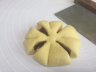 8、花朵豆沙面包,收好口后，收口朝下，按压成饼状，用刀切8刀中间不要切断；