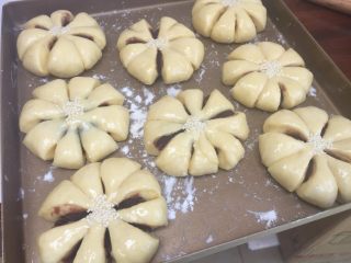 10、花朵豆沙面包,表面刷上蛋液，中间粘上芝麻；