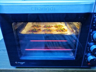 8、饺子皮辣酱饼,放入预热好的烤箱，放入中层180度上下火烤5分钟。