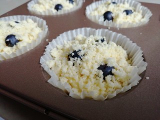 14、金酥粒蓝莓爆浆蛋糕,再挤入蛋糕糊8分满，表面放上三粒草莓，撒上酥粒