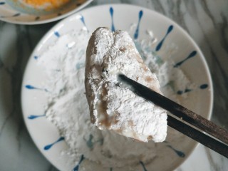10、香酥炸鸡翅,沾好蛋液的鸡翅放入淀粉中滚一下,使鸡翅包裹淀粉。