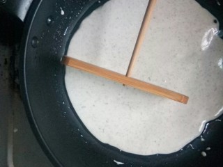 6、风味杂粮煎饼果子,用竹刮摊平。