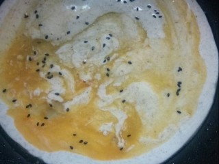 7、风味杂粮煎饼果子,打入鸡蛋，撒上黑芝麻。